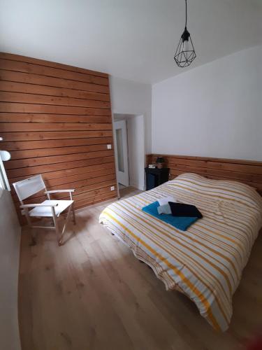 a bedroom with a large bed and a chair at Centre ville Douarnenez in Douarnenez
