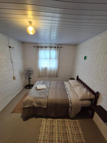 a bedroom with a large bed and a window at Casa Hermena in Santa Vitória do Palmar
