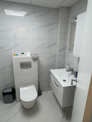 a white bathroom with a toilet and a sink at Nik 2 in Kruševac