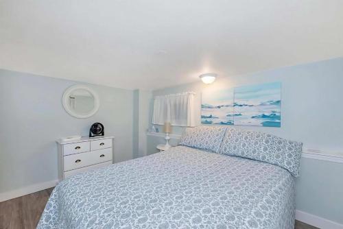 a bedroom with a bed with a blue bedspread at Quaint 1 bedroom lower suite in Victoria, BC in Victoria