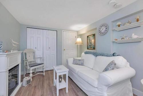 a living room with a white couch and a fireplace at Quaint 1 bedroom lower suite in Victoria, BC in Victoria