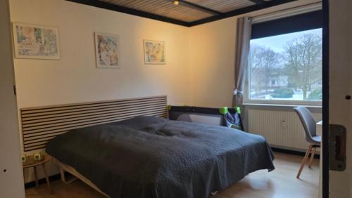 a bedroom with a bed and a large window at Plads til børnefamilien i hjertet af Esbjerg in Esbjerg