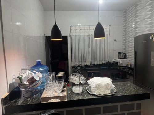 a kitchen with a counter with dishes on it at Casa de temporada in Trindade