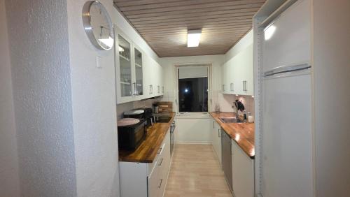 a kitchen with white cabinets and a wooden ceiling at Plads til børnefamilien i hjertet af Esbjerg in Esbjerg