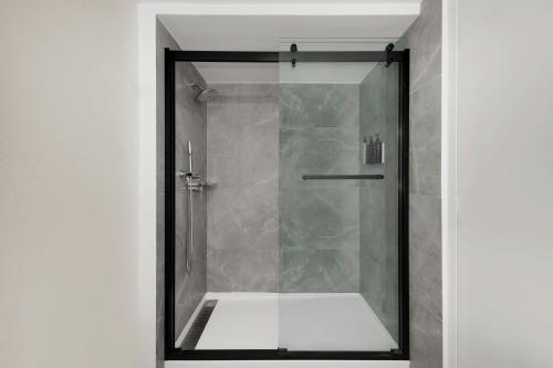 a shower with a glass door in a bathroom at Sheraton Hotel Metairie New Orleans in Metairie
