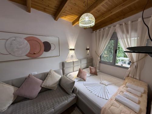 a living room with a couch and a window at villa Heljos apartaments in Vlorë
