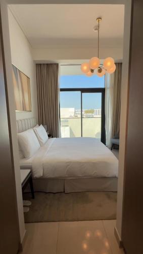 a bedroom with a bed and a large window at ADDRESS RESIDENCES BEACH RESORT BAHRAiN in Rayyā