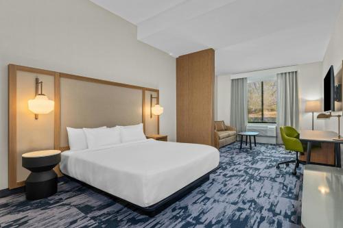 a hotel room with a large bed and a desk at Fairfield Inn & Suites Dixon in Dixon