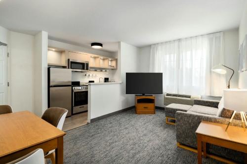 a living room with a couch and a flat screen tv at TownePlace Suites by Marriott Anaheim Maingate Near Angel Stadium in Anaheim