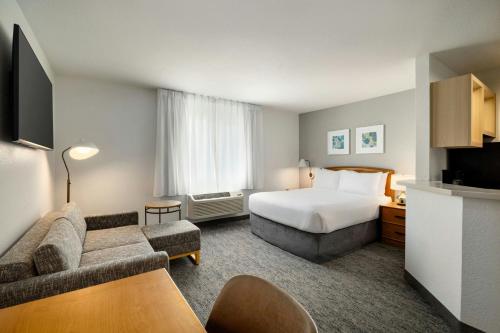 a hotel room with a bed and a couch at TownePlace Suites by Marriott Anaheim Maingate Near Angel Stadium in Anaheim