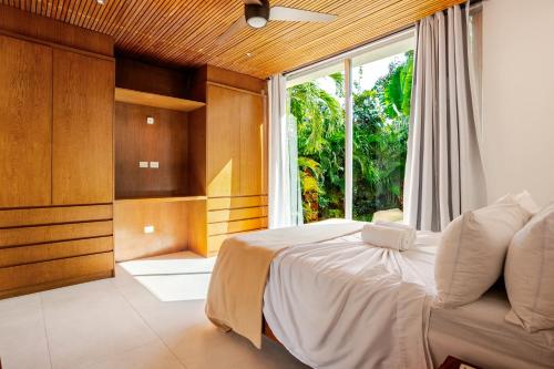 a bedroom with a bed and a large window at 11BR I Hacienda Zalama in Tulum
