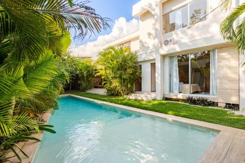 a swimming pool in front of a house at 11BR I Hacienda Zalama in Tulum