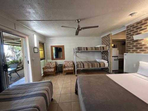 a bedroom with two bunk beds and a balcony at Tweed River Motel in Murwillumbah