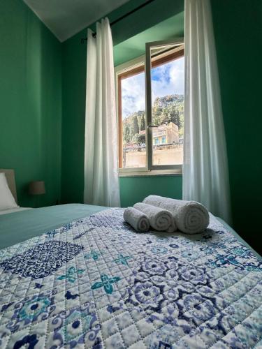 a bedroom with a bed with two towels on it at Casa Amelia - Charme in Taormina in Taormina