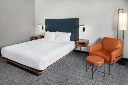 a hotel room with a bed and a chair at Courtyard by Marriott Huntsville University Drive in Huntsville