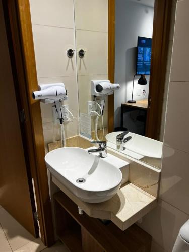 a bathroom with a white sink and a mirror at Ap Tryp by Wyndham Nações in Brasília