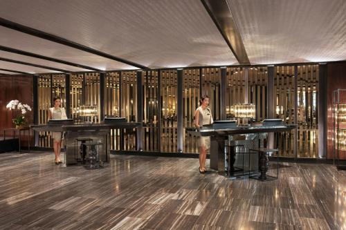 two women standing in a room with two tables at Bangkok Marriott Marquis Queens Park in Bangkok