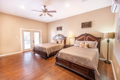 a bedroom with two beds and a ceiling fan at Messina Inn in Wimberley
