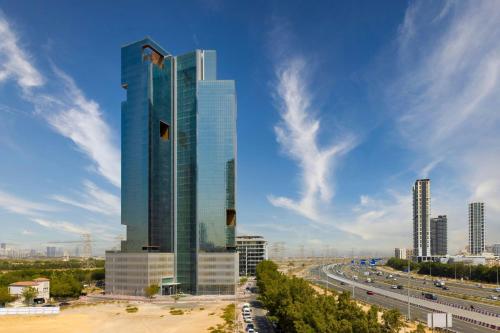 a tall building in a city with a highway at Hotel Local Dubai, Jumeirah Village Triangle, Autograph Collection in Dubai