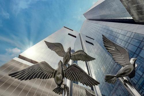 a group of birds flying in front of a building at Hotel Local Dubai, Jumeirah Village Triangle, Autograph Collection in Dubai