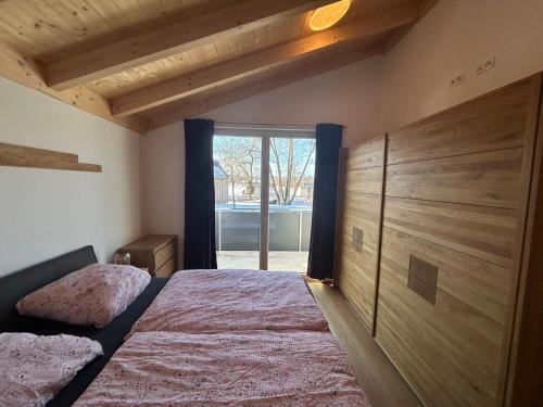 a bedroom with a bed and a large window at Mein Haus am See in Waldkirchen