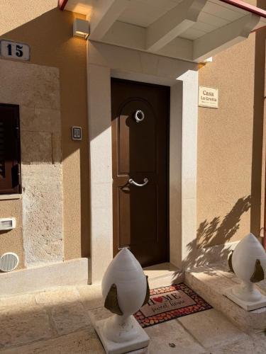 a front door of a house with two statues in front at Casa La Grotta in Bitonto