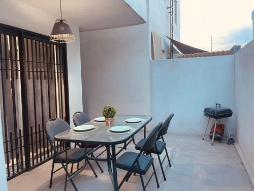 a patio with a table and chairs and a grill at Casa en fraccionamiento privado in Saltillo