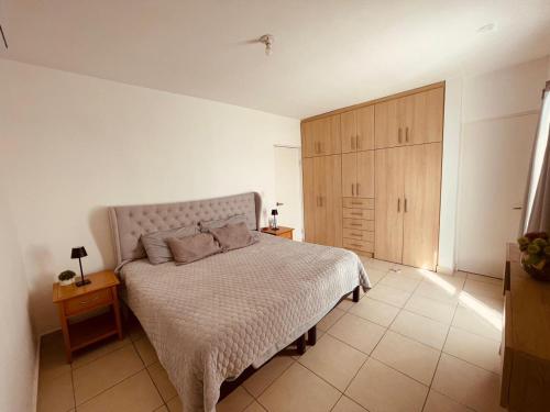 a bedroom with a bed and a wooden cabinet at Casa en fraccionamiento privado in Saltillo