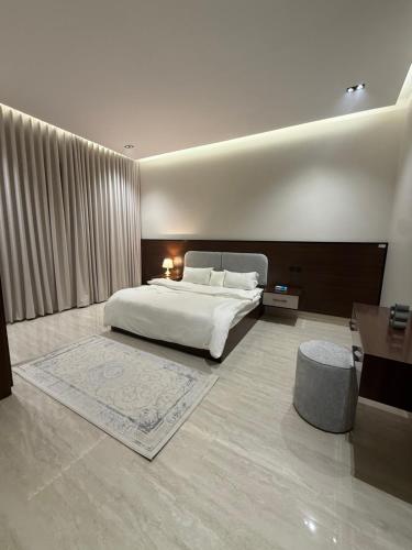 a bedroom with a large white bed and a desk at شقة فاخرة in Al Kharj