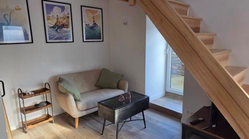 a living room with a couch and a table at Maison Ty Bian Prieuré in Pleubian