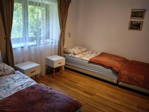a bedroom with two beds and a window at Apartament in Rabka-Zdrój