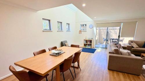 a living room with a wooden table and chairs at Escape to 64 at Cape View Resort in Busselton