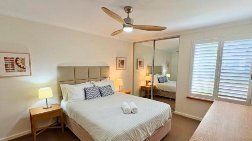 a bedroom with a bed and a ceiling fan at Escape to 64 at Cape View Resort in Busselton