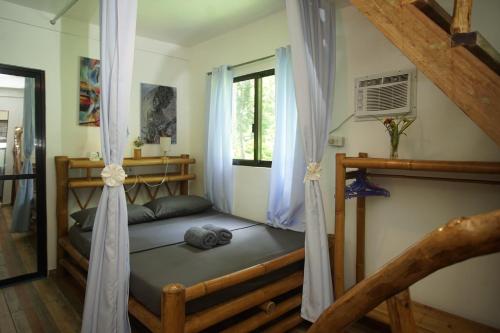 a bedroom with a bed and a window at Sun House Rental in Mambajao