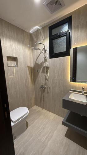 a bathroom with a shower and a toilet and a sink at شقة فاخرة in Al Kharj