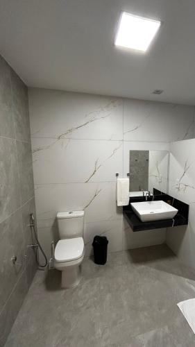 a bathroom with a toilet and a sink at Seridó Acomodações in Caicó