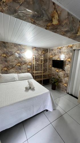 a bedroom with a bed and a stone wall at Kit net morro de são Paulo in Cairu