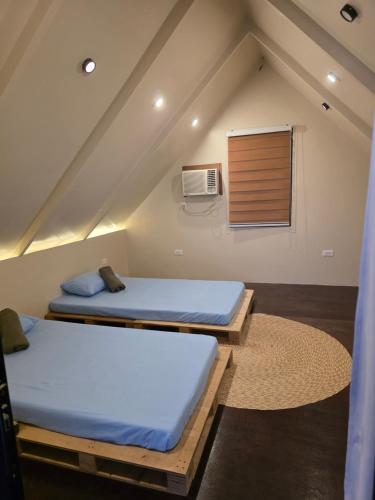 two beds in a room with a attic at Romantic Ocean View A-Frame with Shore Diving Access - Aloha Aina Dive Resort in Mabini