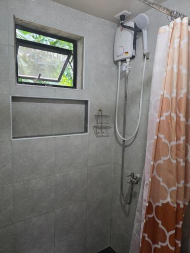 a bathroom with a shower with a window at Romantic Ocean View A-Frame with Shore Diving Access - Aloha Aina Dive Resort in Mabini