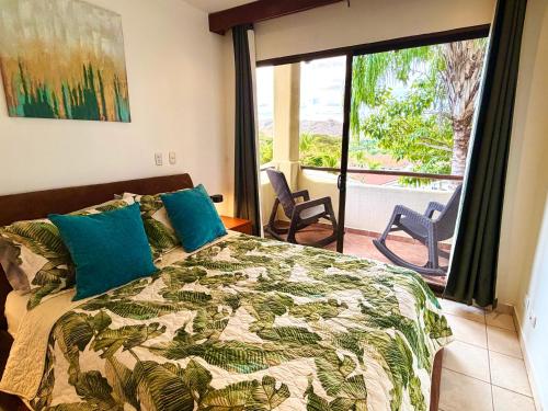 a bedroom with a bed with a view of a balcony at Breezy Paradise 2 bed2bath with mountain view in Coco
