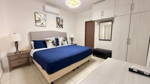 a bedroom with a bed with a blue comforter at Sunset Point San Carlos in San Carlos