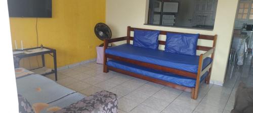 a bedroom with a bed with blue sheets and a fan at Perequê Açu beach house in Ubatuba