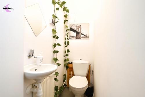a bathroom with a white toilet and a sink at MMRent Divine Room in Gdańsk