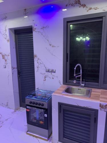 a kitchen with a stove and a sink and a window at Résidence Salt Lake in Pikine