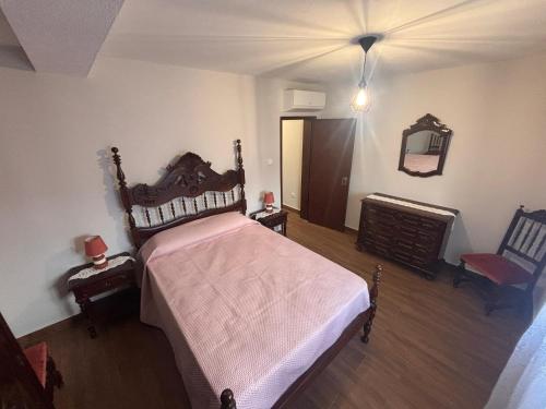 a bedroom with a bed and a chair and a mirror at Refugio do Alto de Levira in Anadia