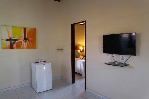 a flat screen tv on a wall in a room at Pousada Sol e Luna - Pipa Garden in Pipa