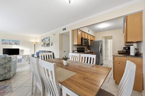 a kitchen and dining room with a wooden table and chairs at Fair Seas Clipper Condo for 6 in Saint Augustine Beach
