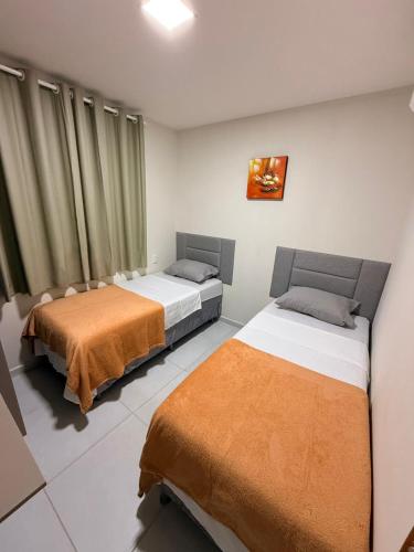 two beds sitting in a room with curtains at Domaine Residence in Gravatá