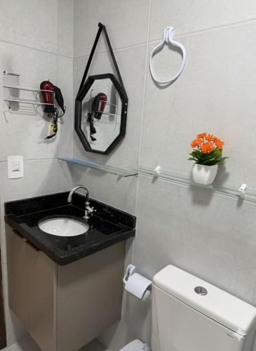 a bathroom with a sink and a toilet and a mirror at Domaine Residence in Gravatá