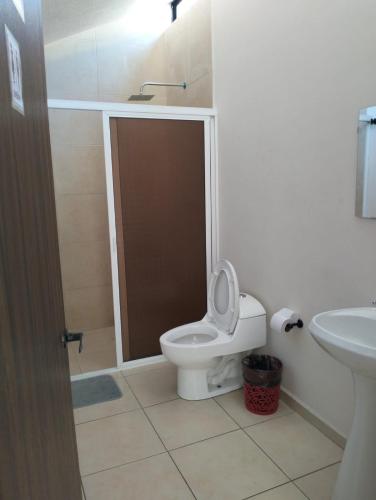 ein Badezimmer mit Toilette und Waschbecken in der Unterkunft Hotel Morelia Nova in Morelia